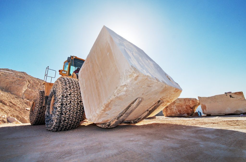 Industrial,Shot,Illustrating,The,Production,Of,Marble.,A,Bulldozer,Moving bburn.nl blokken worden uit het gebergte gesneden en in zogenaamde slabs gezaagd.